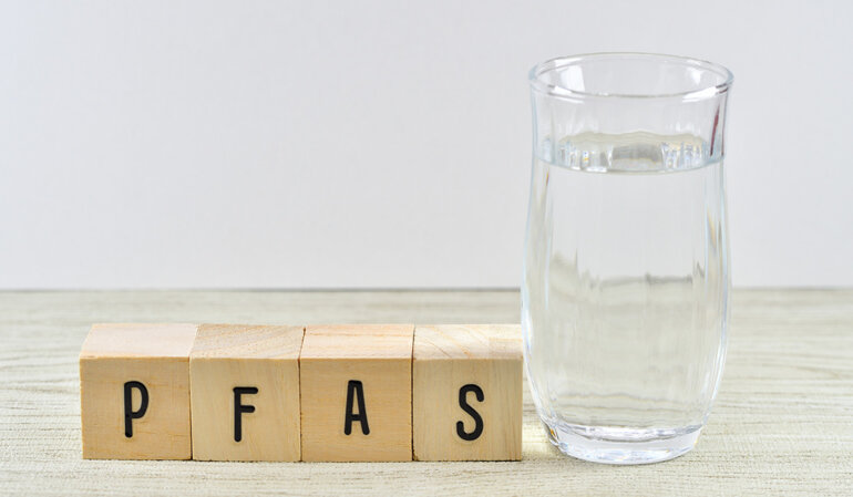 PFAS Symbolbild mit einem Glas Wasser.