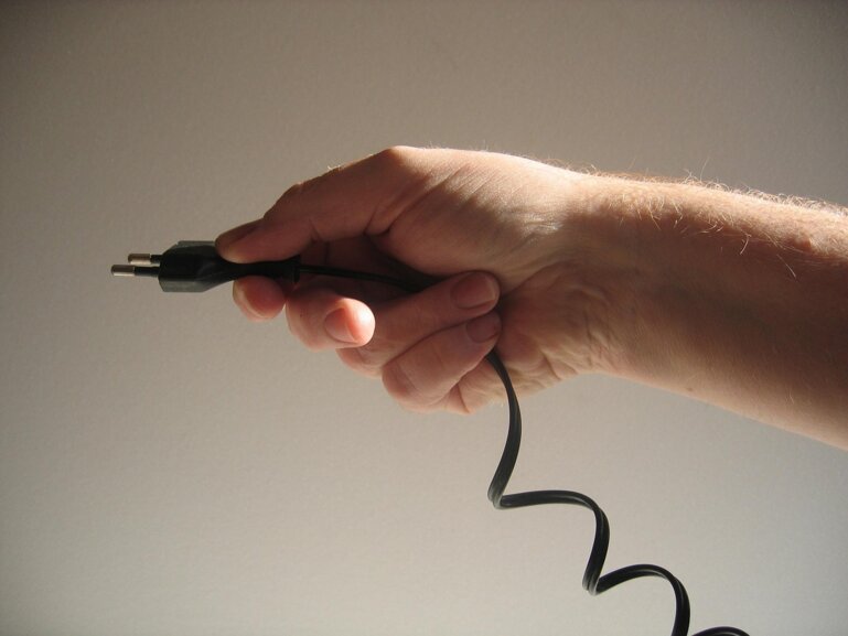 Hand mit Stecker.